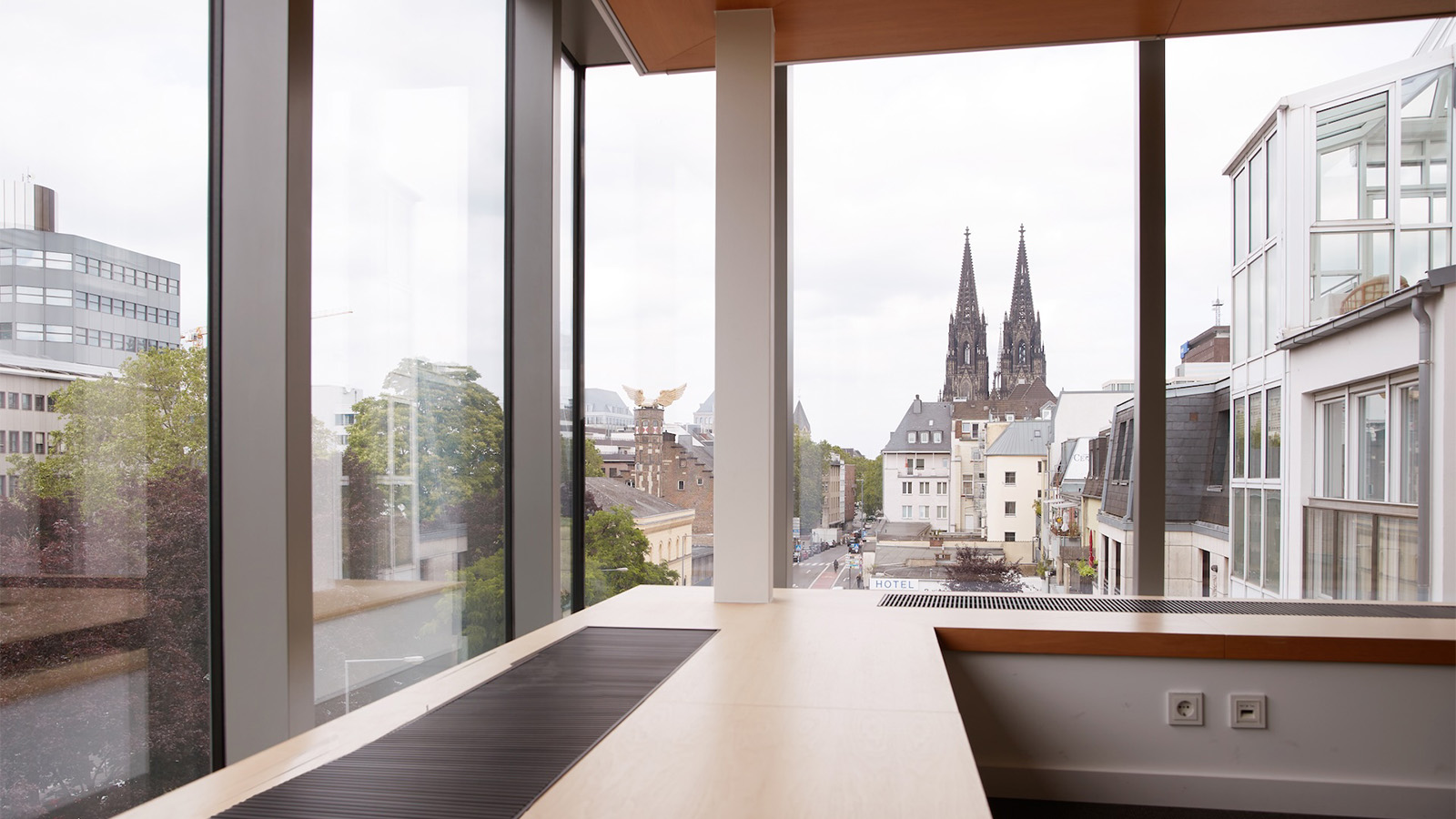 Blick aus einem modernen Büro über die Kölner Innenstadt auf die beiden Türme des Kölner Doms.